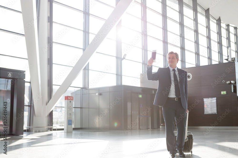Attractive mature businessman walking through his gate for boarding in airport Attractive mature businessman walking through his gate for boarding in airport