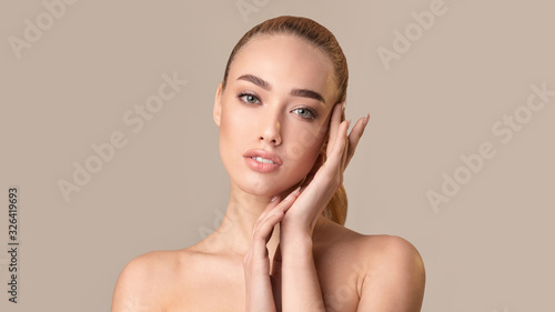 Beautiful Girl Touching Face Posing Over Beige Studio Background, Panorama