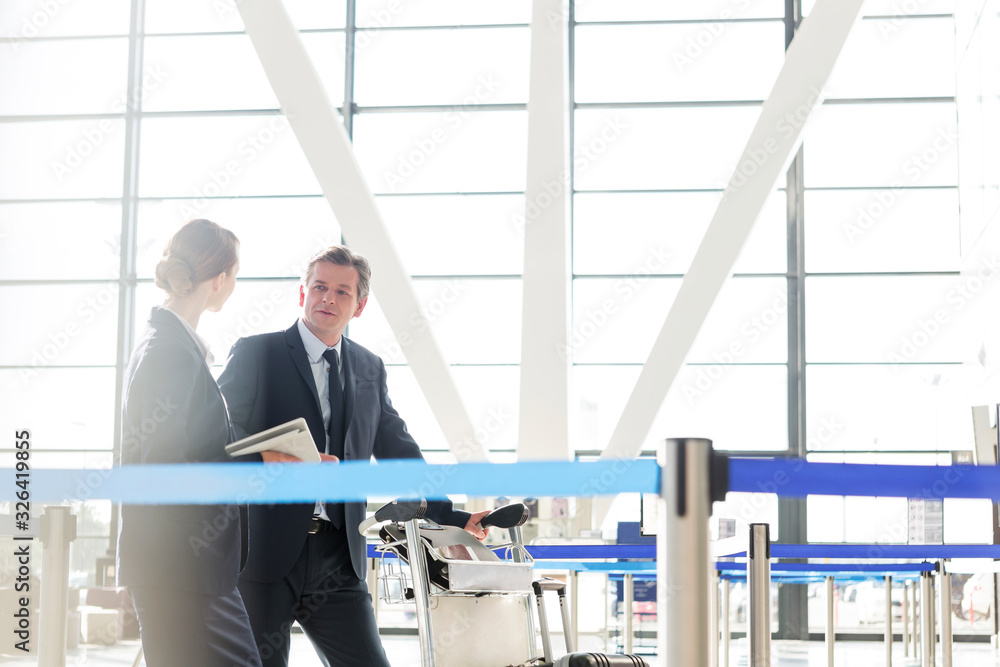 Mature businessman talking with his business partner in check in are at airport Mature businessman talking with his business partner in check in are at airport