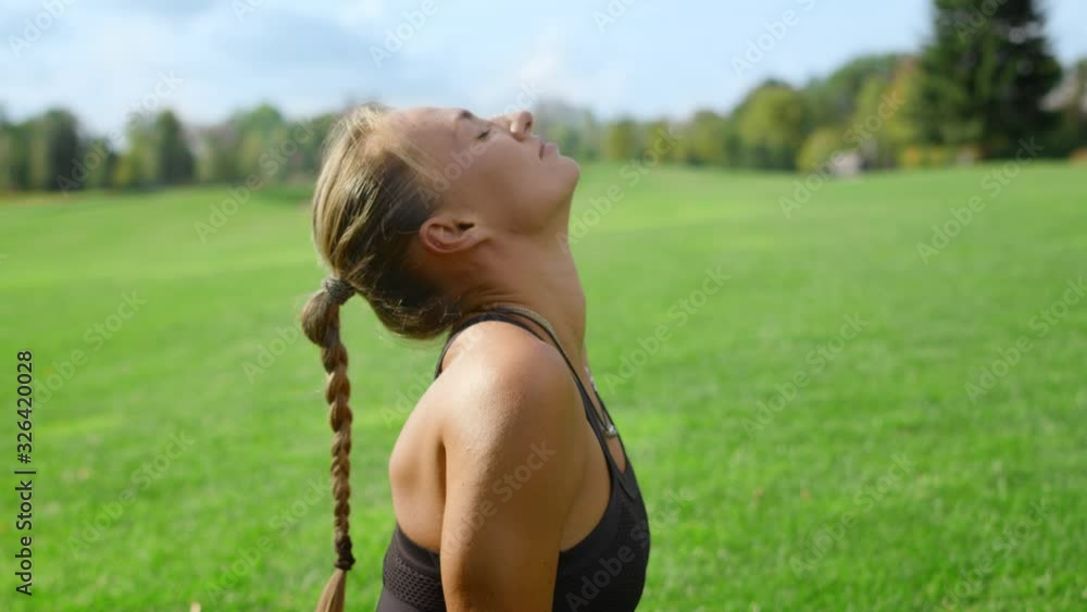 Sportswoman with artificial limb doing yoga in park. Woman stretching in field Sportswoman with artificial limb doing yoga in park. Woman stretching in field
