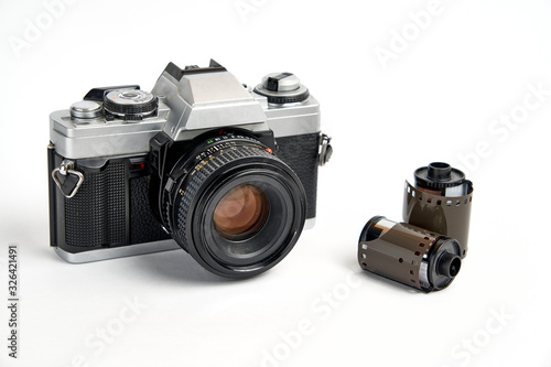 Classic analog 35 mm camera vintage and analog film rolls on white background