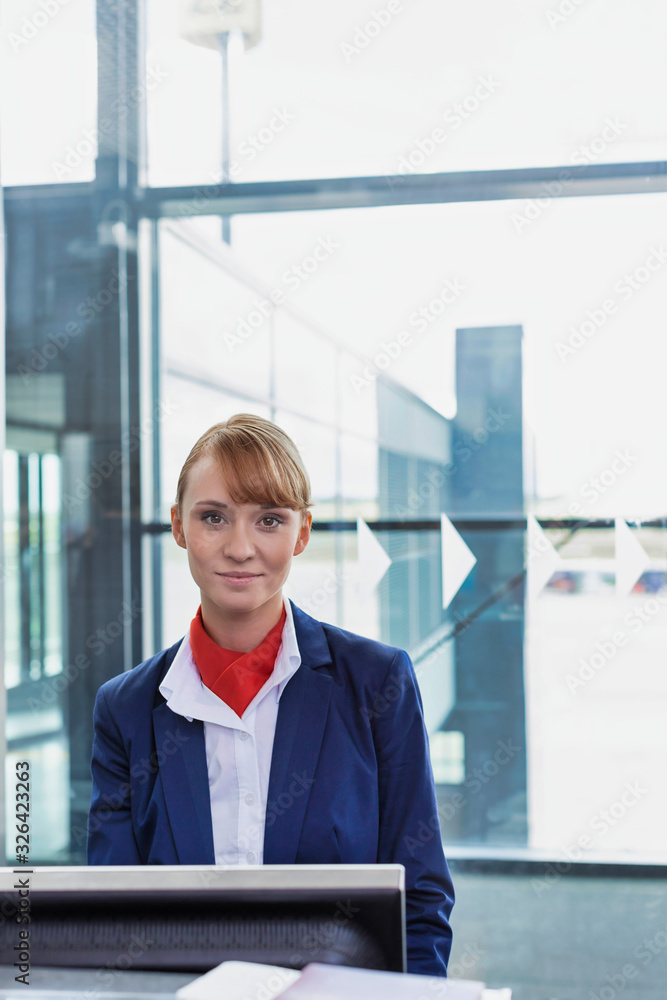 Portrait of young attractive passenger service agent standing in airport gate Portrait of young attractive passenger service agent standing in airport gate