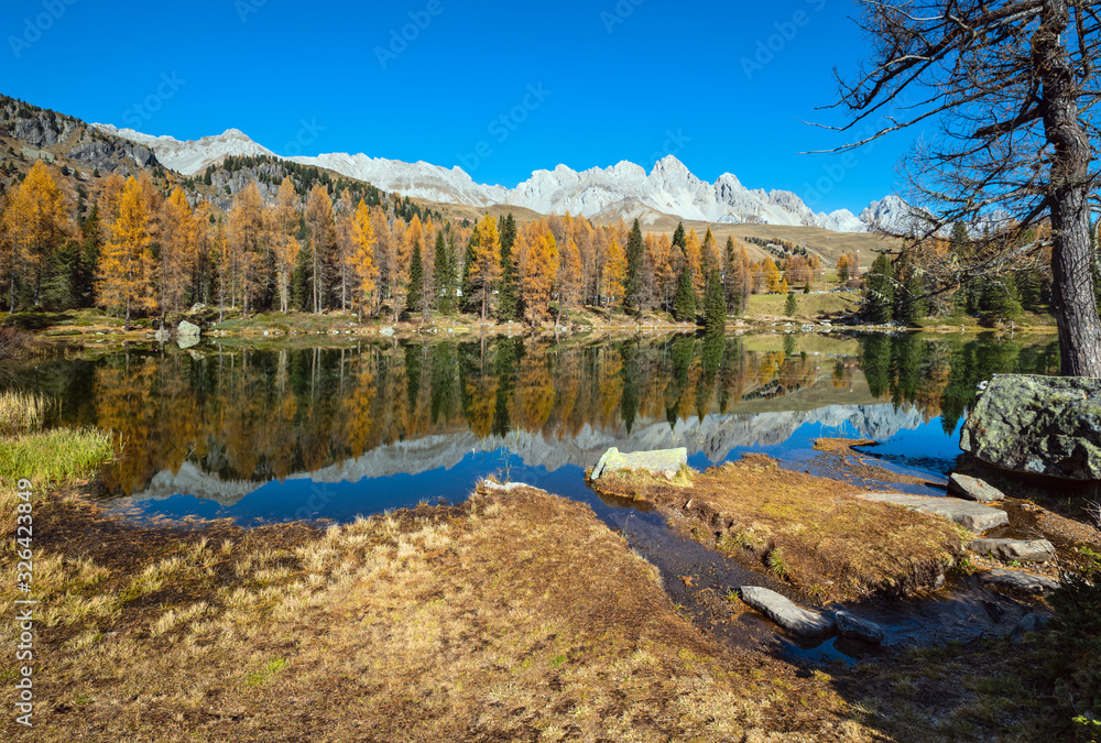 Autumn alpine mountain lake near San Pellegrino Pass, Trentino, Dolomites Alps, Italy.