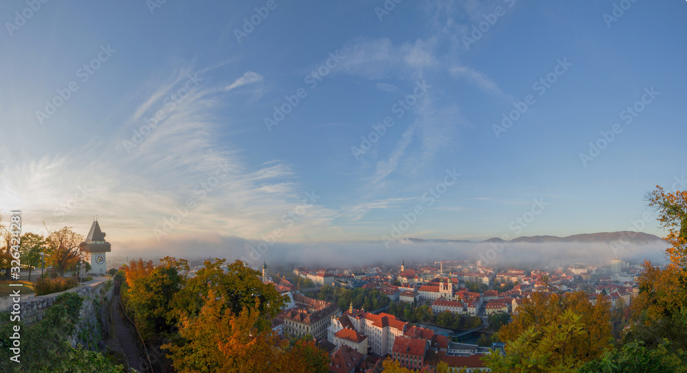 Cityscape of Graz and the famous clock tower (Grazer Uhrturm) on Shlossberg hill, Graz, Styria region, Austria, in autumn. Panoramic view.