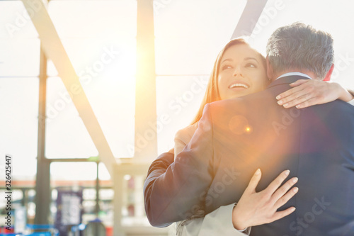 Konstfotografi Business couple reuniting and embracing each other in the airport