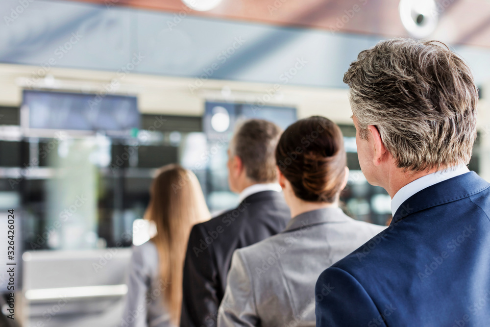 Business people queueing for check in at airport Business people queueing for check in at airport