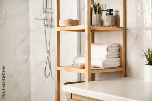 Shelving unit with clean towels in bathroom interior © New Africa