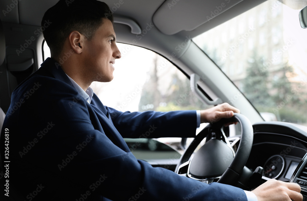 Handsome man in suit driving his modern car Handsome man in suit driving his modern car