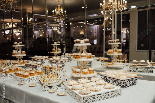 Sweet table. A plates of cakes and muffins. Table with sweets, buffet. Dessert table for a party goodies for the wedding. Candy bar. Decorated delicious