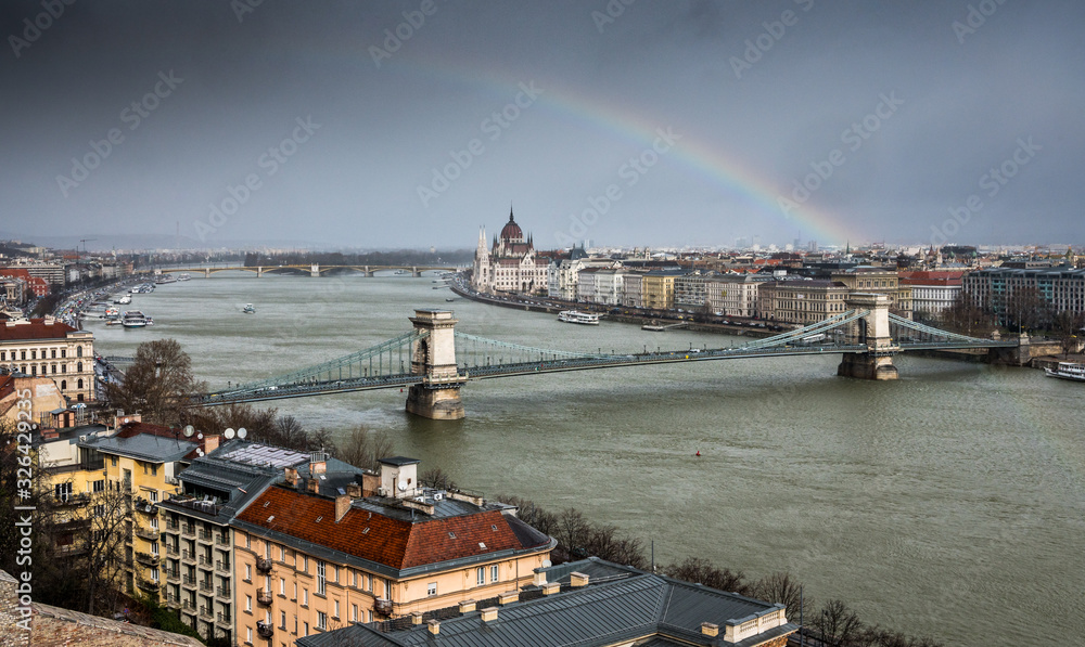 Chain Bridge over Danube in Budapest with Hungarian Parliament and a rainbow in Budapest