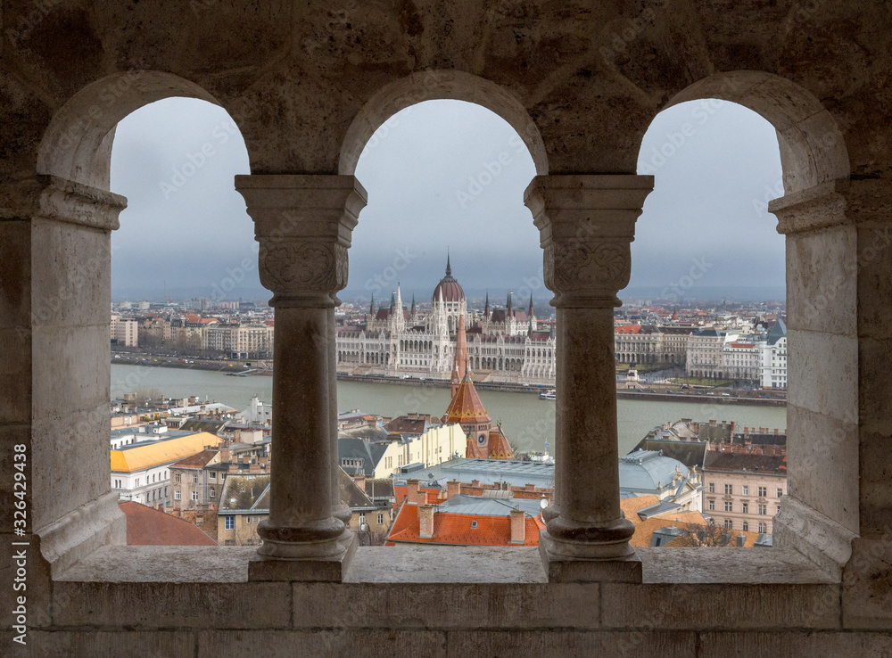 Hungarian Parliament Building seen through the arcades of fishermans bastion on Buda Castle Hill, Budapest with