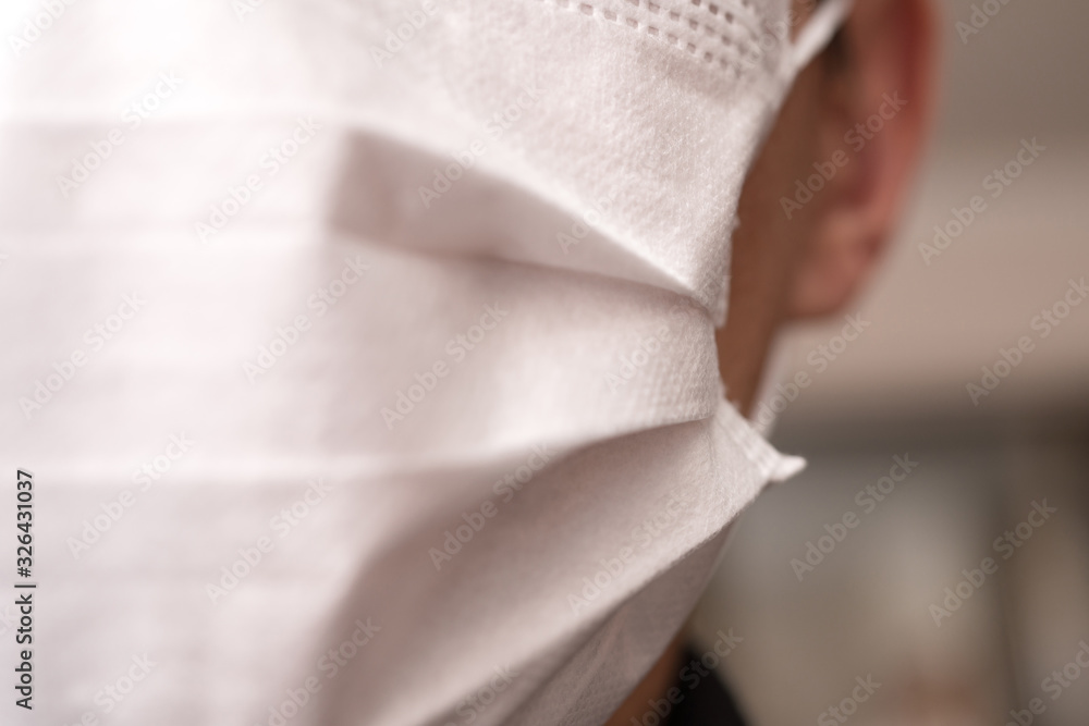 Closeup with the face of a young man wearing medical or surgical mask Closeup with the face of a young man wearing medical or surgical mask