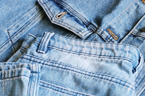 Light blue denim clothes closeup photography. Denim jacket and pants flat lay photo. Spring and summer clothes