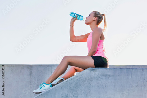 Young attractive woman sitting while drinking energy drink