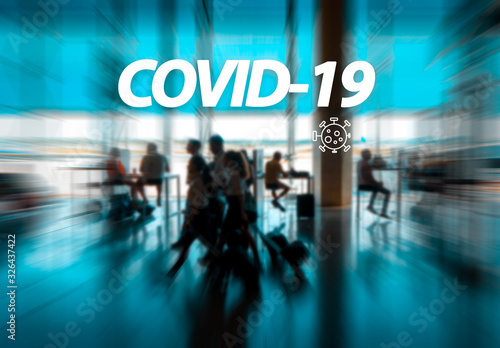 Covid-19 word with airport passengers on the background. Symbolizing the global spread of the coronavirus through global air traffic