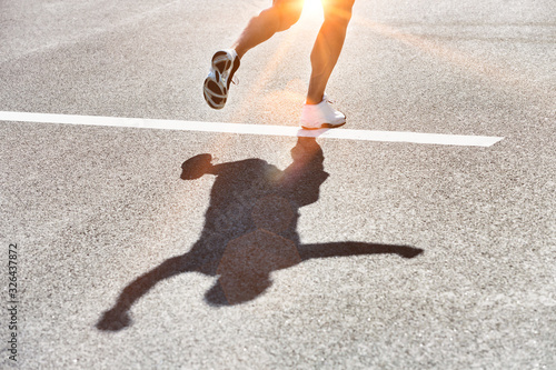 Man running on white starting finsihing line with lens flare coming though photo