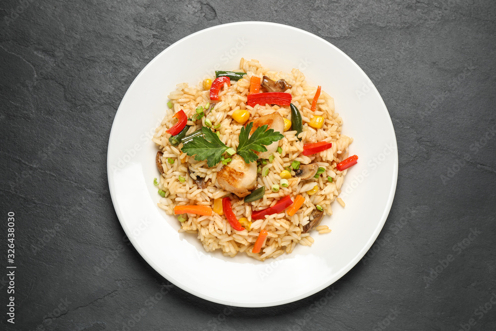 Delicious rice pilaf with chicken and vegetables on black table, top view Delicious rice pilaf with chicken and vegetables on black table, top view