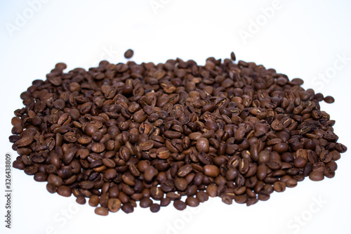 Roasted coffee beans pile isolated on white background. Selective focus.