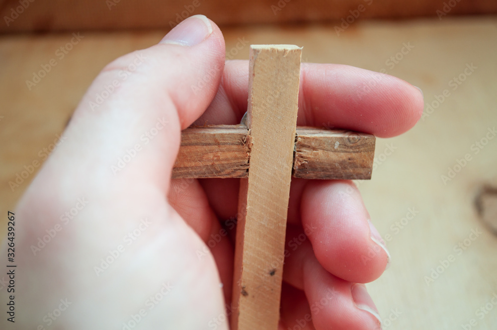 Fototapeta premium Hand holds wooden cross, easter day, world prayer day, international prayer day