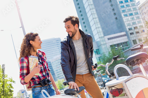 Portrait of attractive couple riding bicycle in the middle of the city © moodboard