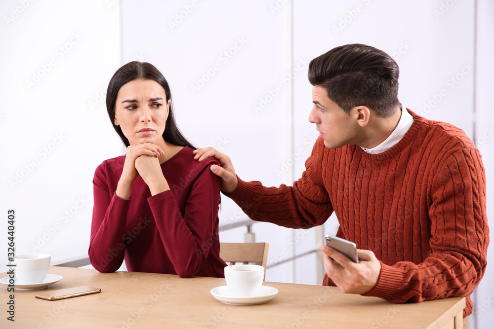 Unhappy couple with relationship problems at table in cafe Unhappy couple with relationship problems at table in cafe