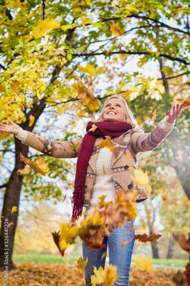 Portrait of beautiful woman playing with maple leaves in park Portrait of beautiful woman playing with maple leaves in park