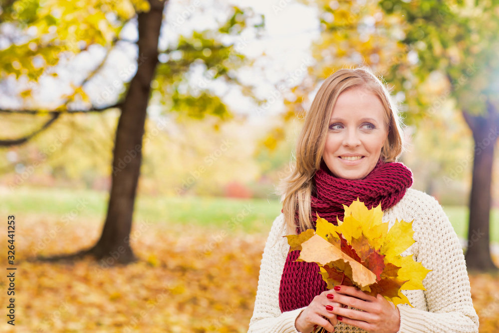 Portrait of beautiful woman holding maple leaves in park Portrait of beautiful woman holding maple leaves in park