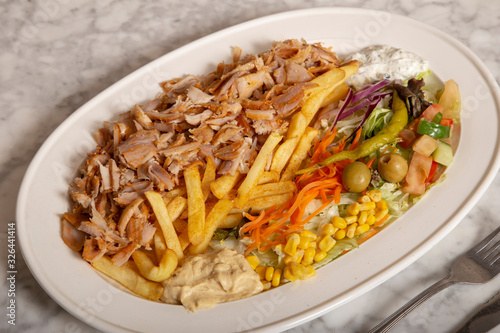 Turkish food dish. Chicken kebab meat, hummus fries and salad.