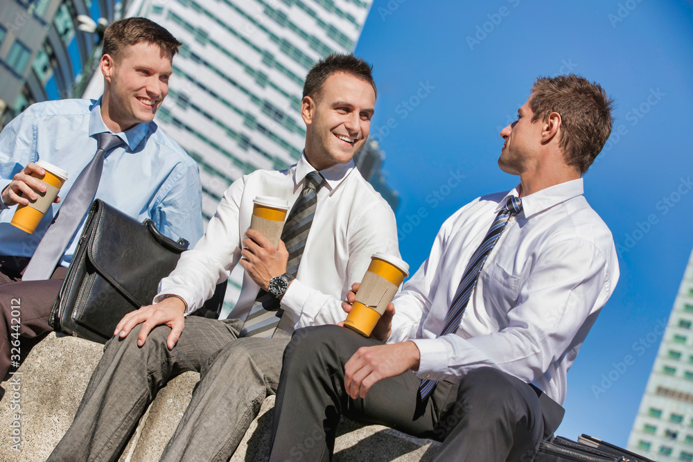 Group of colleagues sitting and talking while drinking coffee after work Group of colleagues sitting and talking while drinking coffee after work