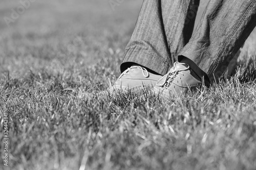 Black and white photo of businessman foot on the grass