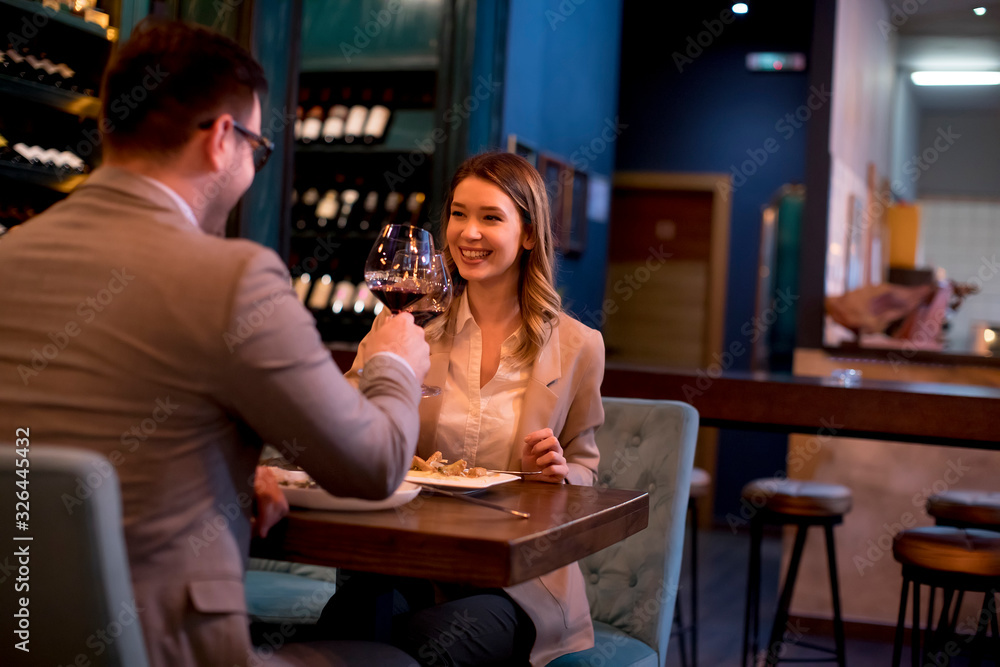Young couple having a dinner in the restaurant and drinking red wine