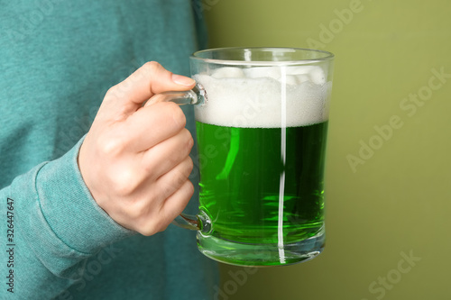Woman with green beer on color background, closeup. St. Patrick's Day celebration