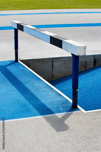 Photo of blue running tracks with steeplechase jump barrier