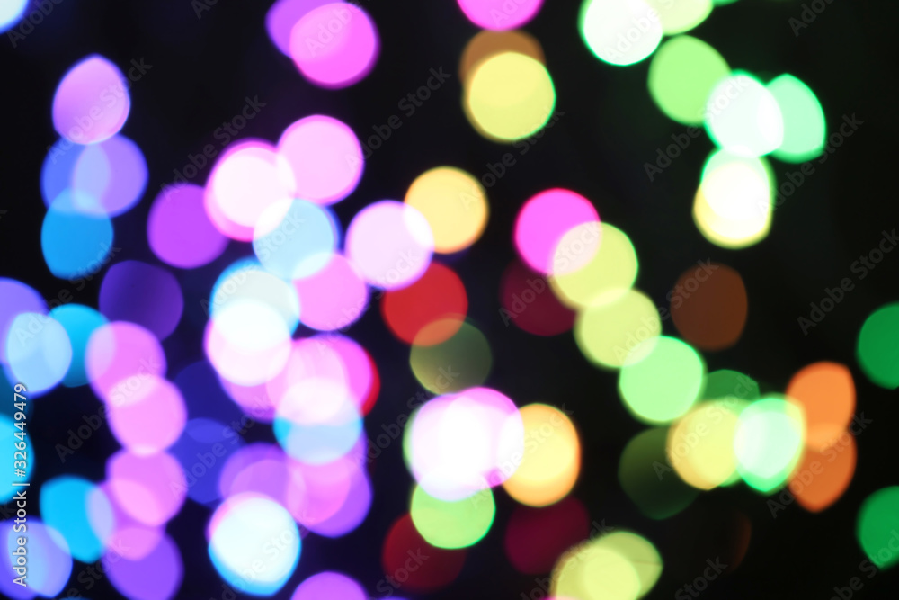 Fototapeta premium Blurred view of colorful lights on black background. Bokeh effect