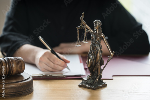 justice and law concept. Female judge in a courtroom on wooden table and Counselor or Male lawyer working in office. Legal law, advice and justice concept.