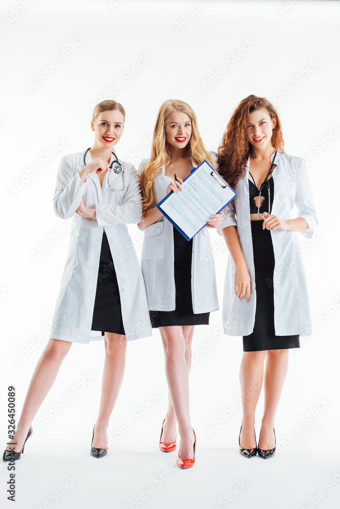 sexy nurses in white coats smiling near clipboard on white sexy nurses in white coats smiling near clipboard on white