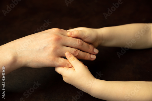 Holding hands, clapping like friends. Close up shot of female and kid's hands doing different things together. Family, home, education, childhood, charity concept. Mother and son or daughter, wealth.