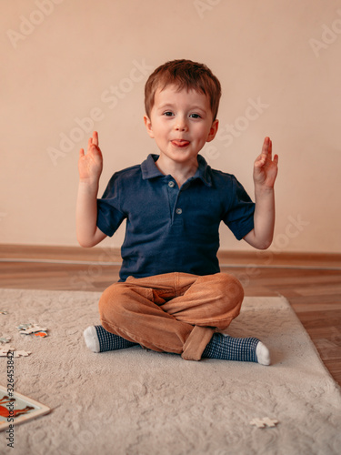 Little boy is meditating in the lotus position and smyling. yoga for young children photo