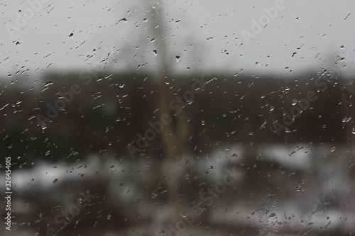 raindrops on the window on a blurred background of inclement weather