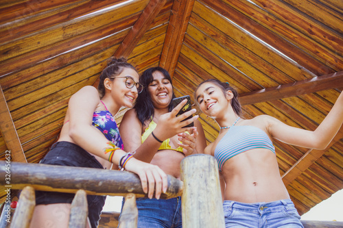 Group of young girl friends having fun with a smartphone  photo