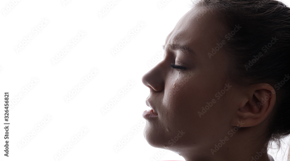 Beautiful young sad woman crying with closed eyes. White background. Free space for text. Tear on cheek of unhappy female. Beautiful young sad woman crying with closed eyes. White background. Free space for text. Tear on cheek of unhappy female.