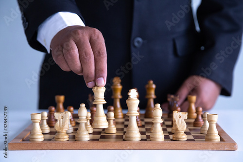  Businessman leadership hand moving of playing chess concept: symbol confident new strategy plan for win and success, sports game thinking battle planning object achievement queen for successful