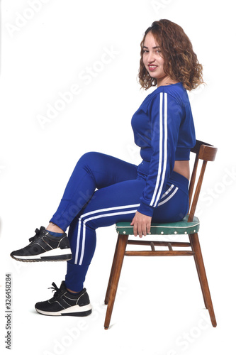 portrait of a woman sitting on a chair in white background,looking at camera,legs crossed photo