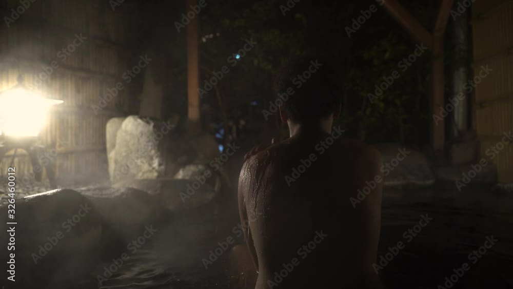 Back View of A Young Female In Outdoor Hot Spring Bath in Japan During Nighttime- Close Up Shot Back View of A Young Female In Outdoor Hot Spring Bath in Japan During Nighttime- Close Up Shot