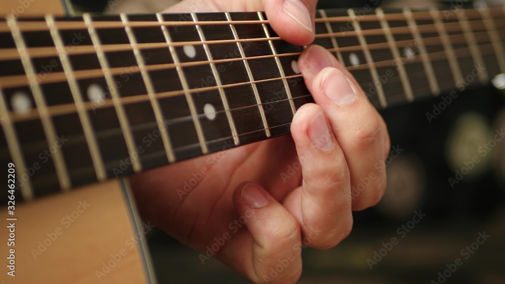 Guitar fretboard close up. The man's fingers touch the strings of the guitar. Guitar fretboard close up. The man's fingers touch the strings of the guitar.