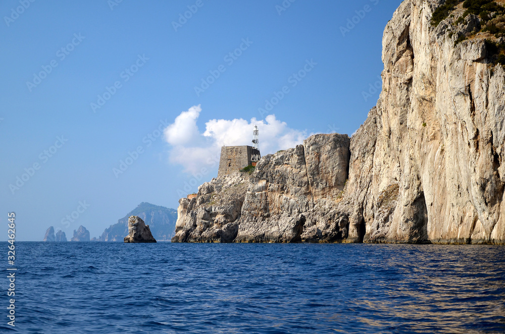 Punta Campanella seen from the sea, in the background the island of Capri and the faraglioni