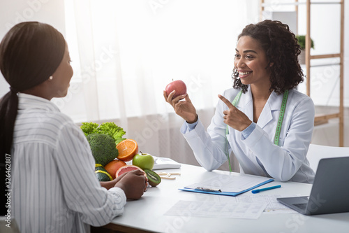 Nutritionist giving consultation to patient with healthy fruit and vegetable photo