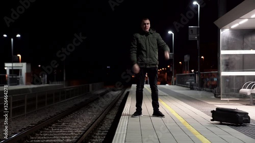 Man waiting for a train and looks irritated because he missed it, he threw his luggage and got mad.