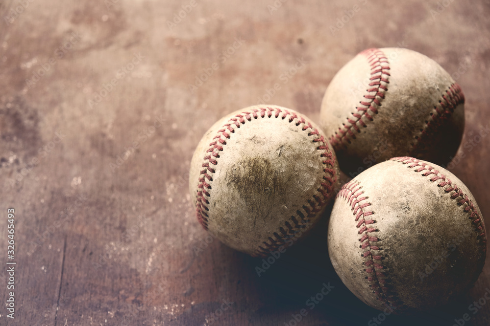 Group of vintage used baseballs close up with brown antique texture background, copy space by balls.