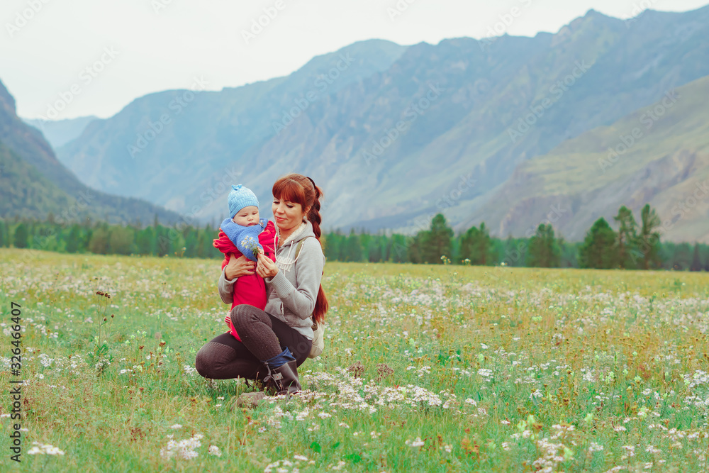 a mother holds a child in her arms in a field